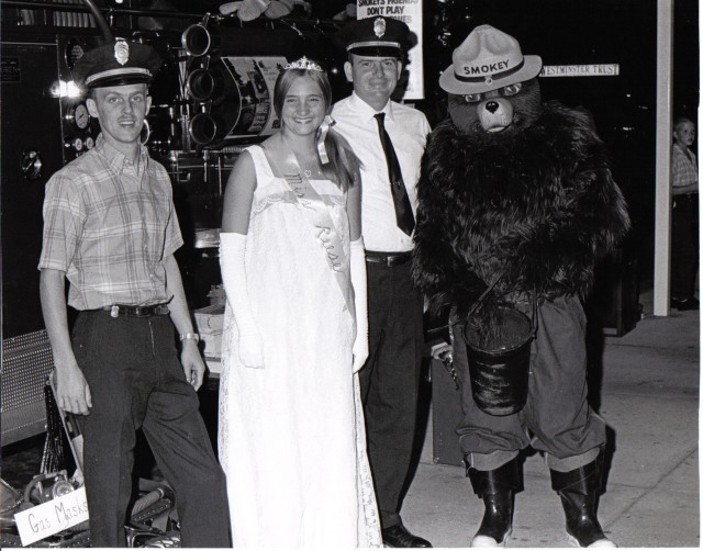 Firefighters Leppo and Link pose with Miss Resse and Smokey the Bear